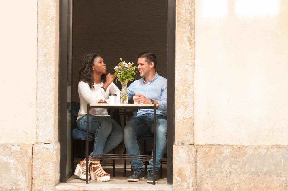 Deux personnes discutent à une table en terrasse